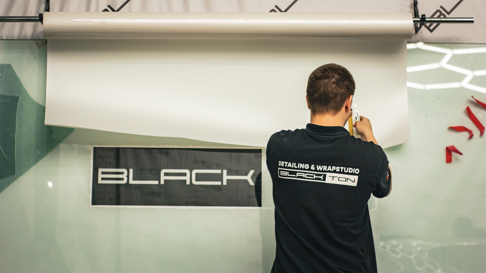 Мастер BlackTon работает с плёнкой у фирменной стены студии